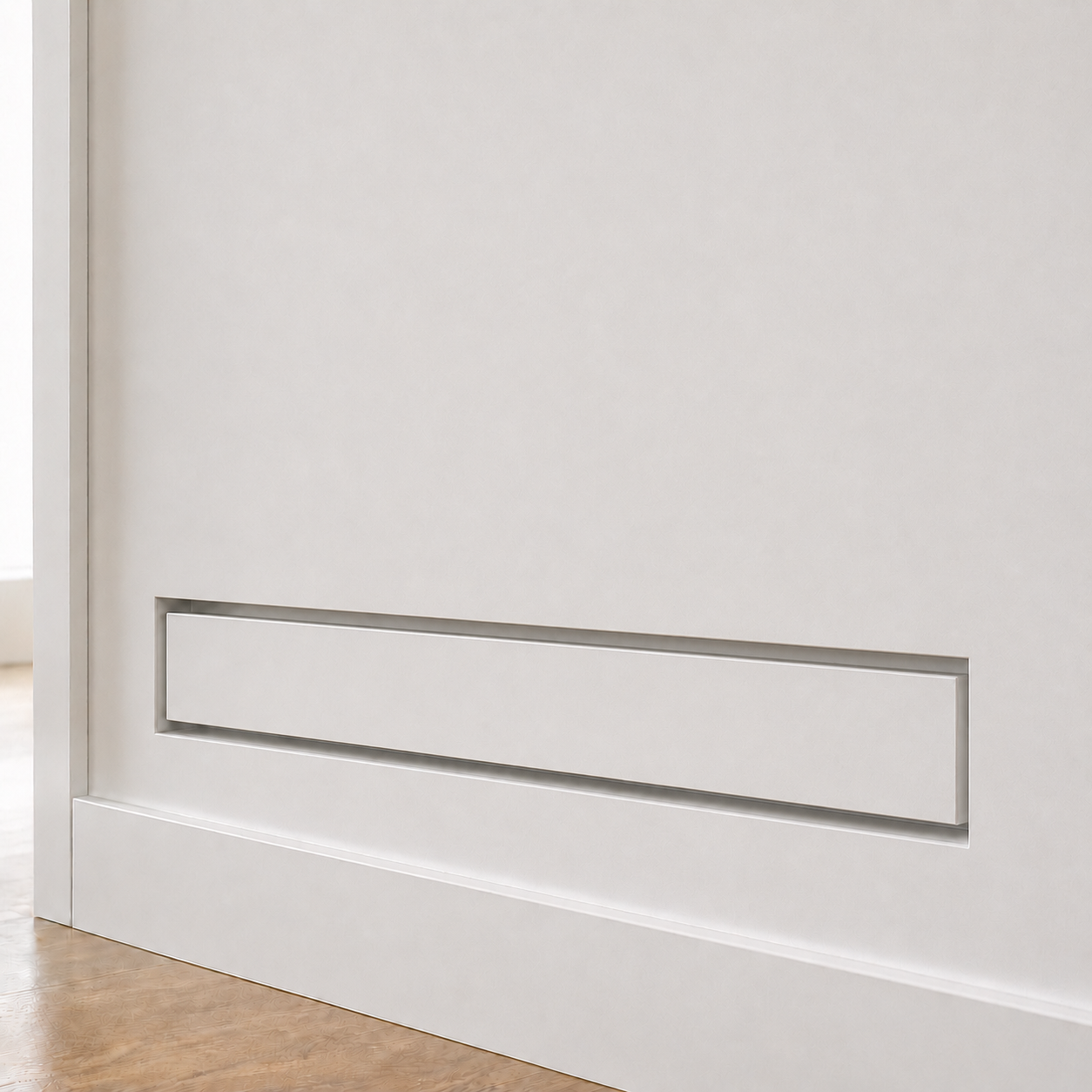 Seam 4×14 flush wall vent installed as a slim horizontal slot in a white wall — the long, low profile reads as architectural detail rather than HVAC hardware